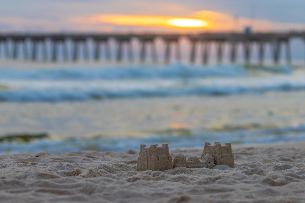Mini sandcastle on the beach at sunset near the pier, capturing the family-friendly charm of Panama City Beach townhome rentals along the shoreline.
